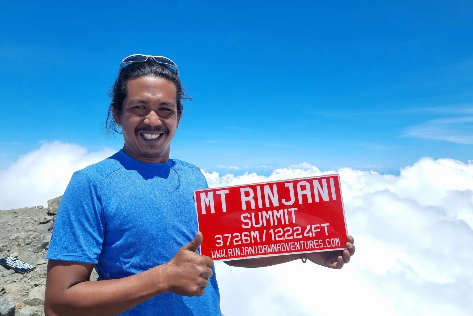 Venture Beyond guide standing on summit of Mount Rinjani, Lombok